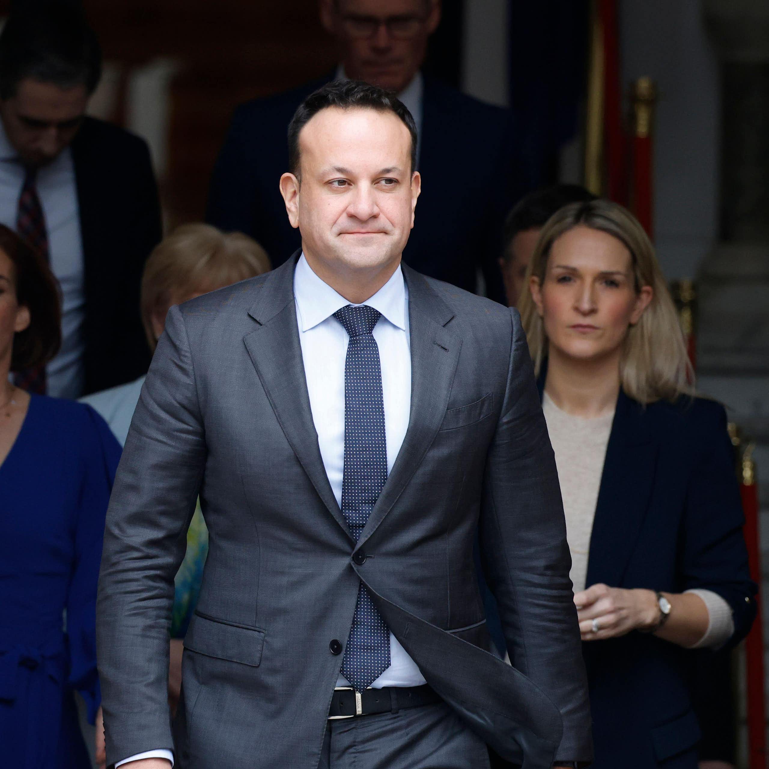 Leo Varadkar walking out of a building with a team of people behind him