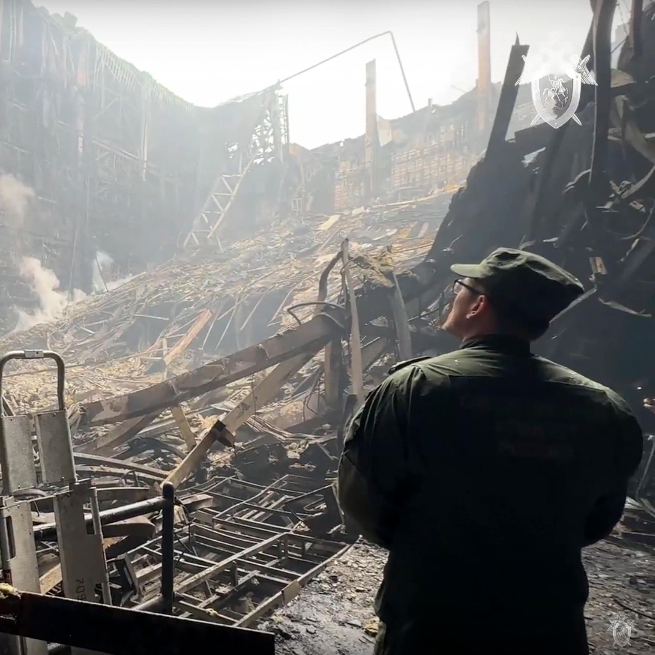 Un homme en treillis militaire observe un immeuble en ruines